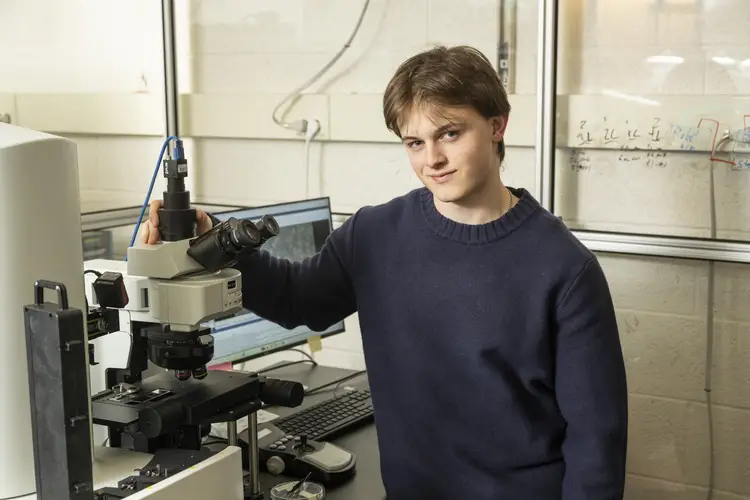 Patrick Kaczmarek in a lab with a microscope. 