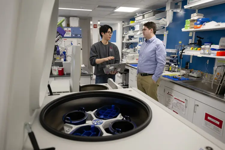 Andreas Pfenning and Stephen Wu conduct research in a lab.