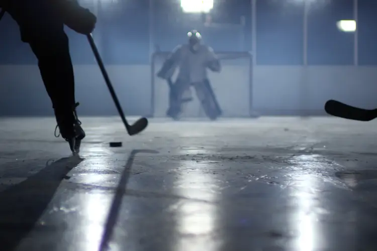 A hockey goalie is shown ready to defend the goal.