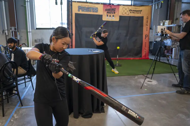 People swing baseball bats in a demonstration. 
