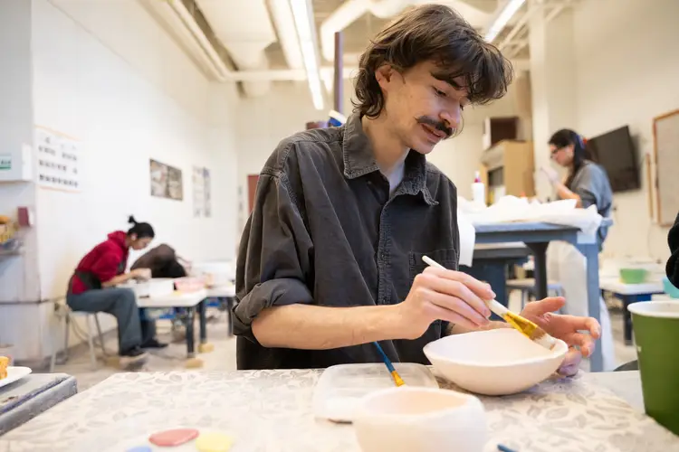 Students work on ‘empty bowls’ at the School of Art ceramic studio.