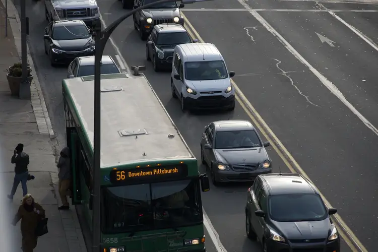 Cars and a bus are shown in heavy traffic